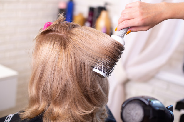 female-hairdresser-s-hand-brushing-blow-drying-blonde-hair-beauty-salon_285484-56